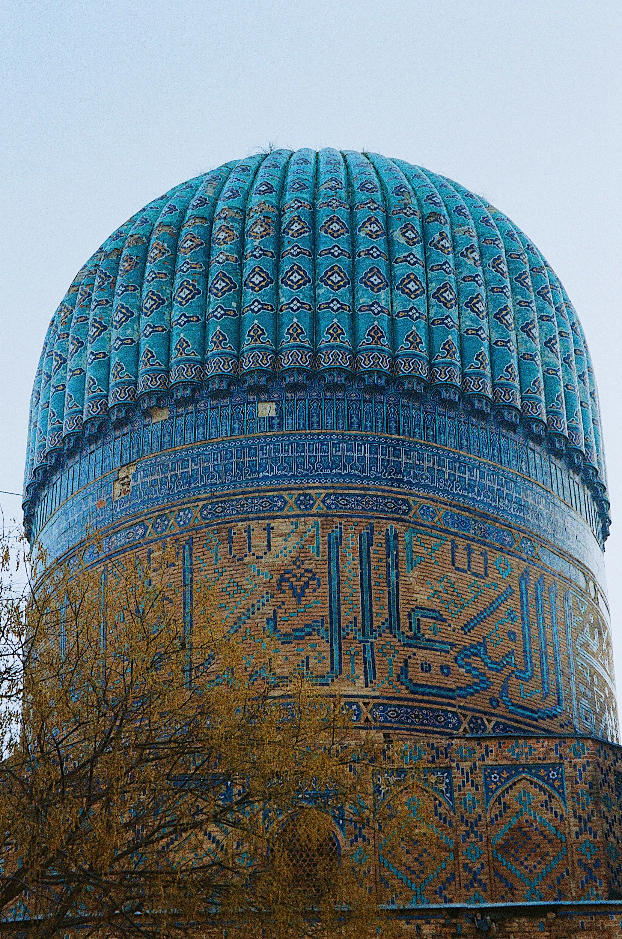 A ribbed turquoise dome against a pale sky