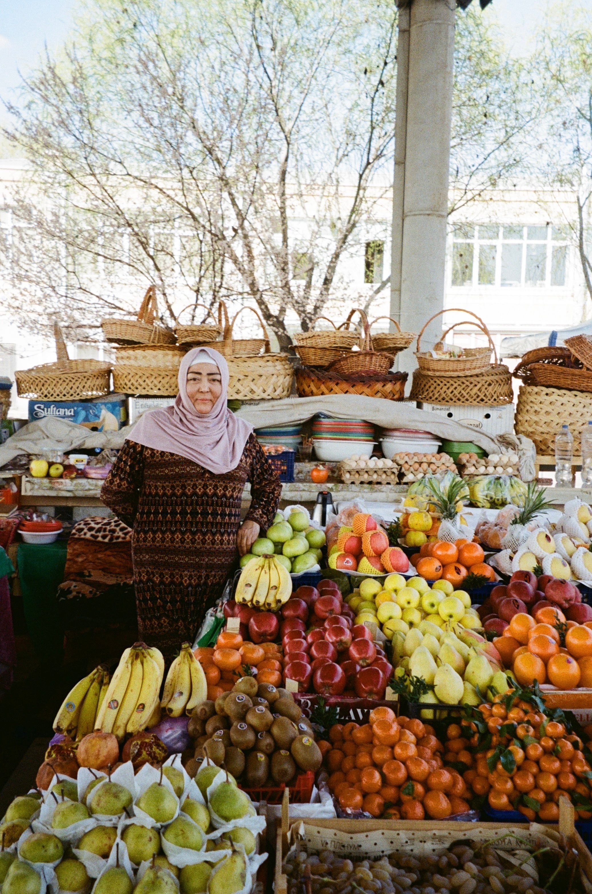 A stallholder behind a market stall piled with fruit