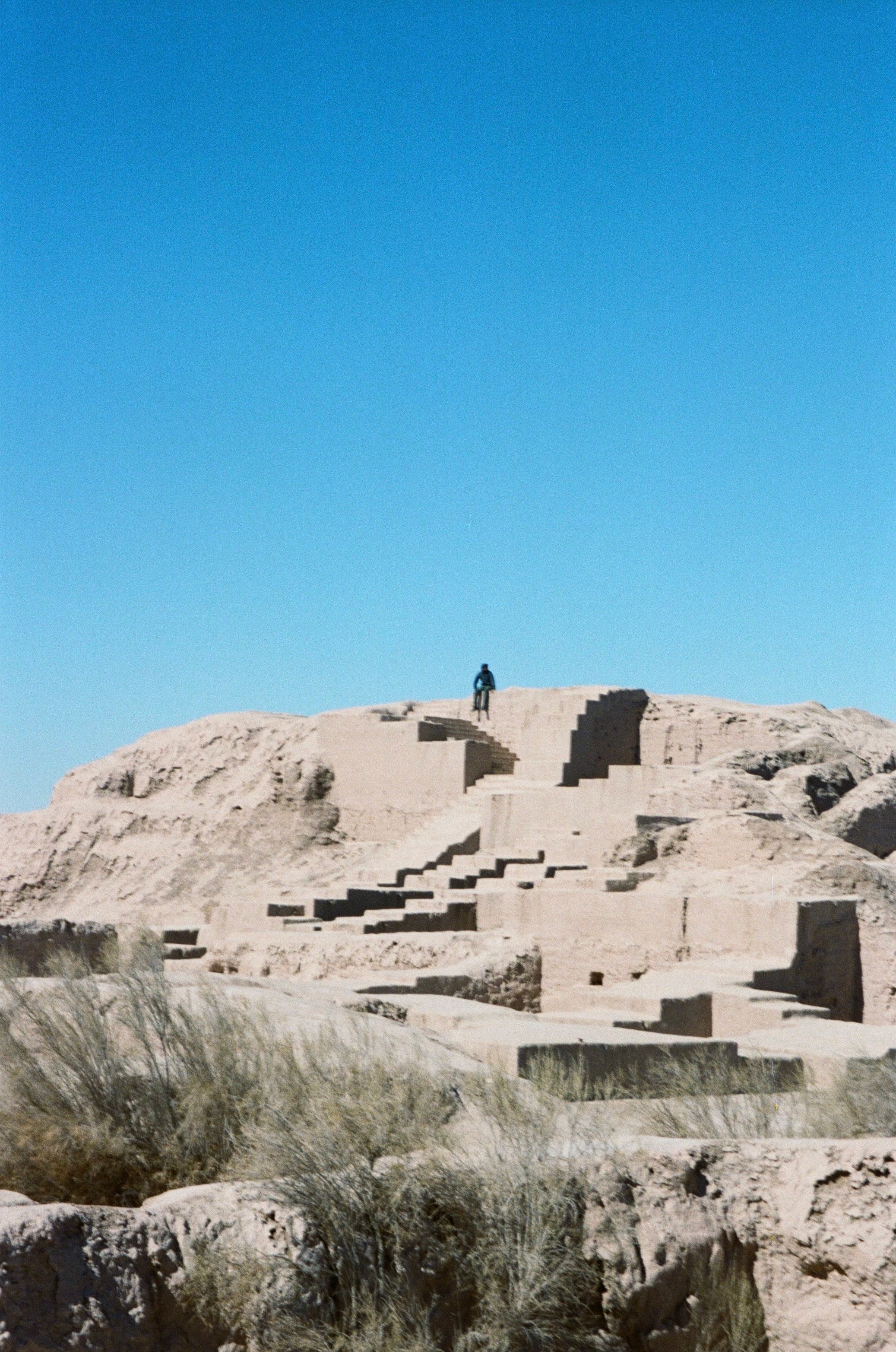 Crumbling mud-brick ruins on a hill under a clear sky