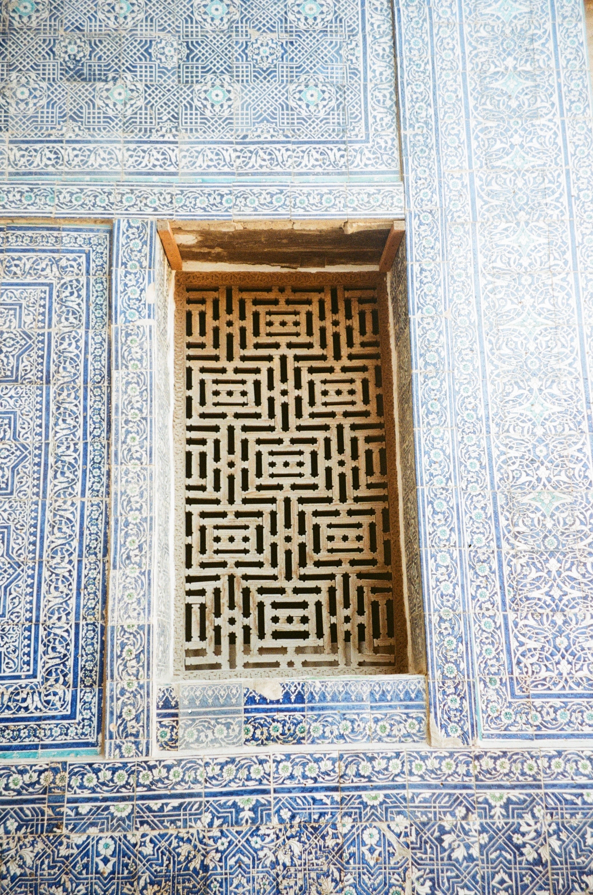 A carved lattice window set in blue tilework
