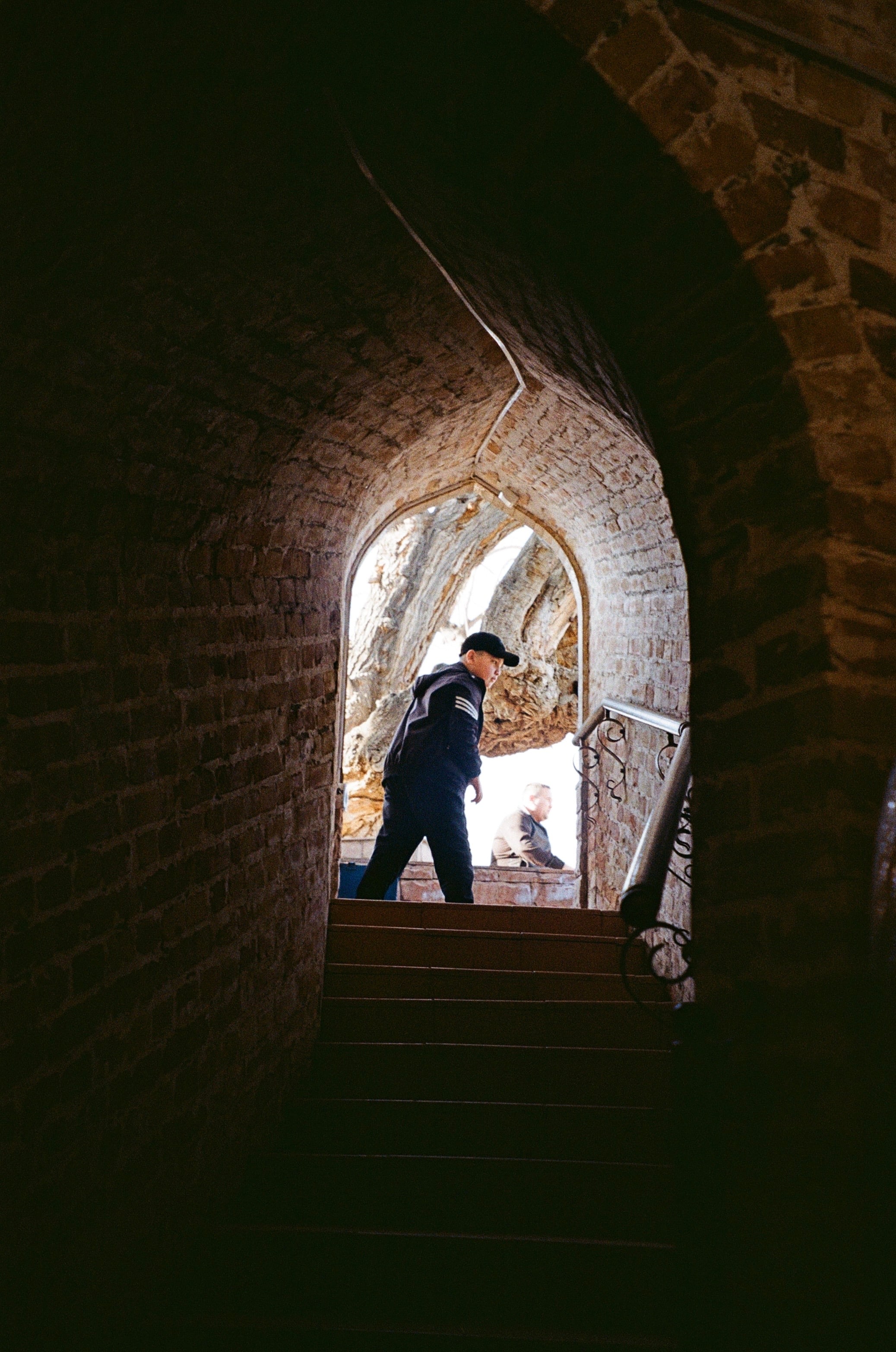 A figure framed by a dark arched doorway
