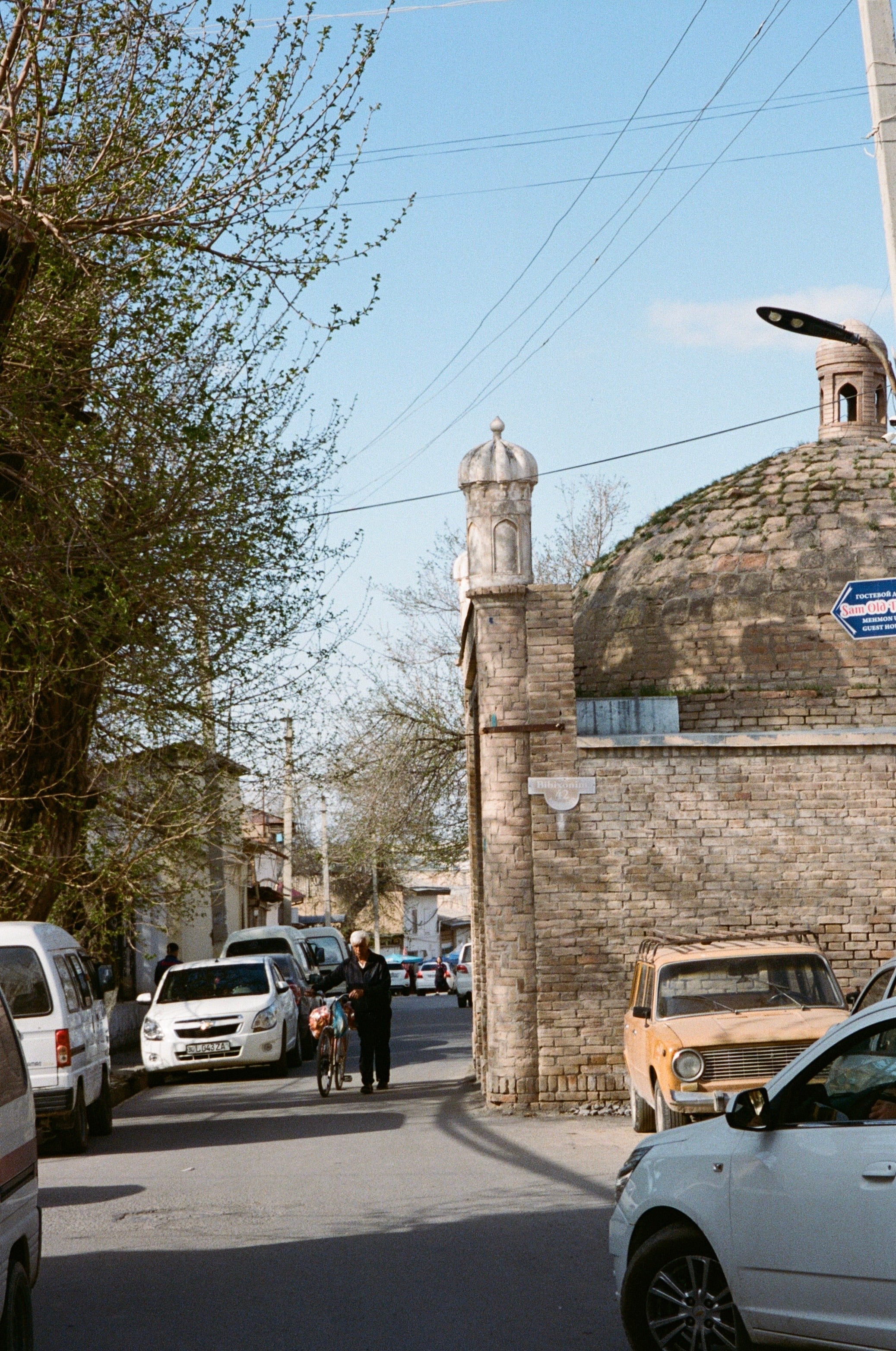 Parked cars along a street beside a minaret