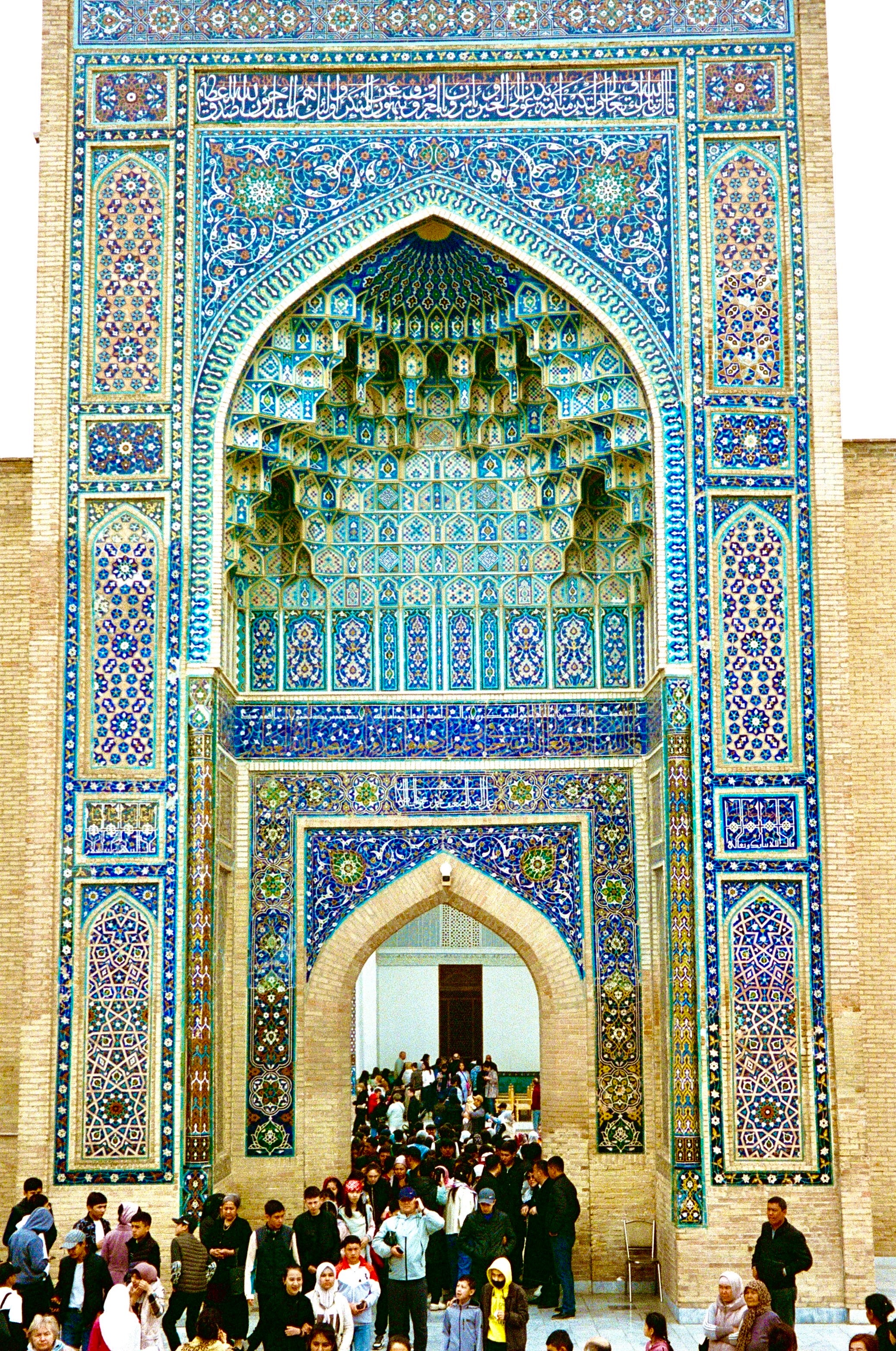 Crowds beneath a richly tiled portal