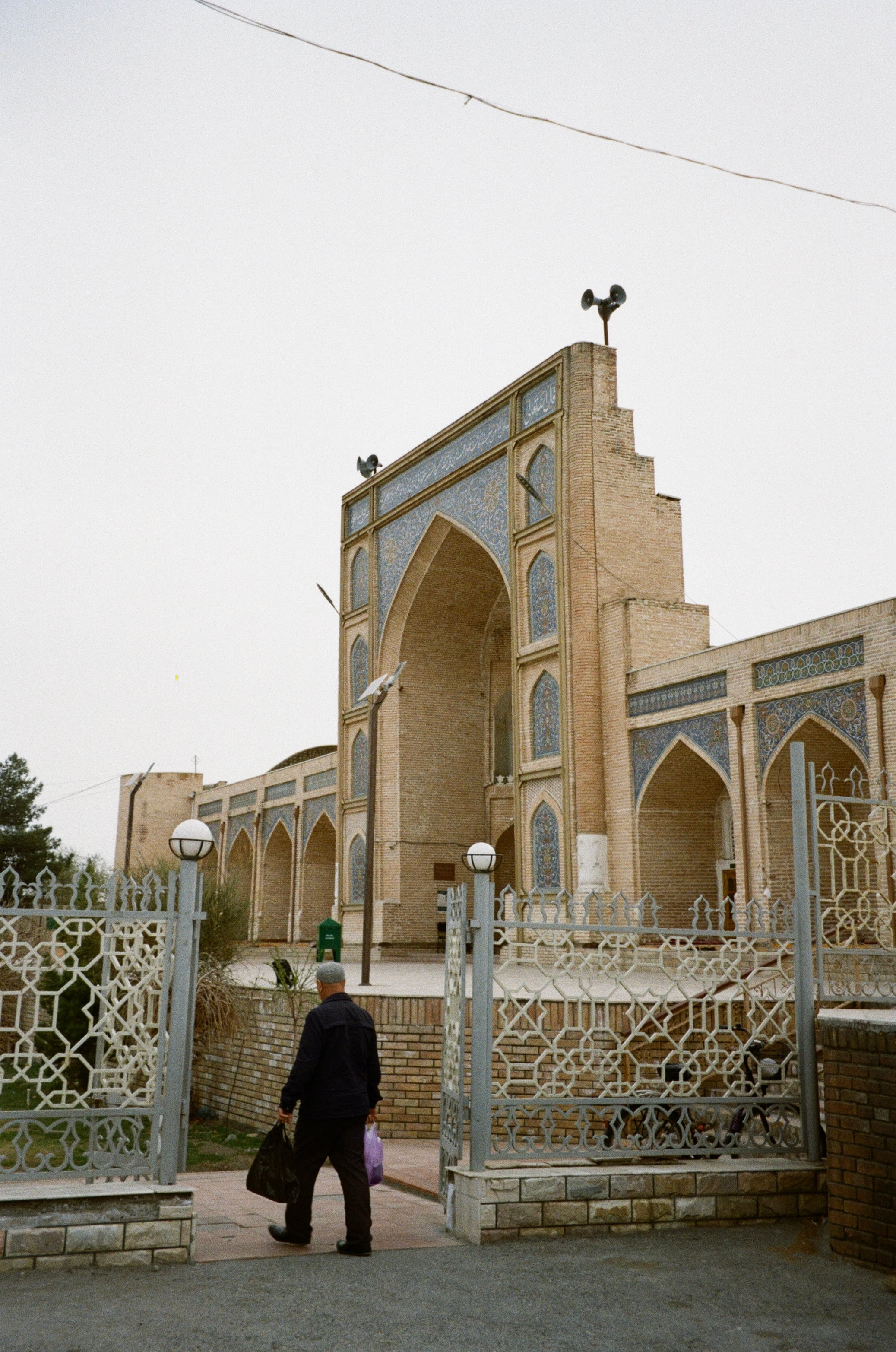A figure walking past an ornate gateway